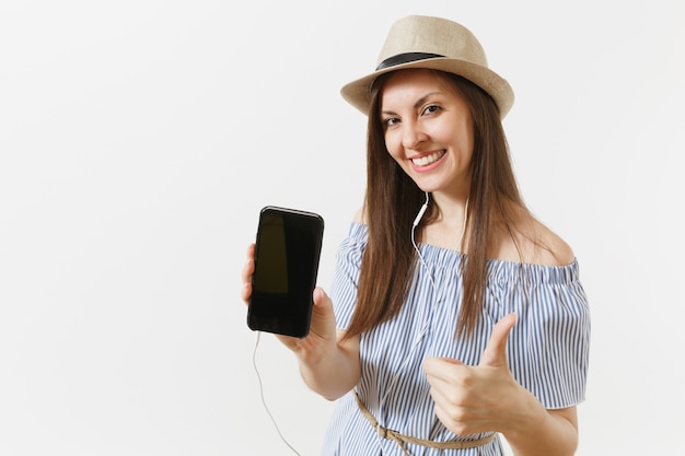 Musica d'ascolto della giovane donna felice di divertimento in auricolari sul telefono cellulare con lo schermo vuoto nero in bianco isolato su fondo bianco. persone, emozioni sincere, concetto di stile di vita. zona pubblicità. copia spazio