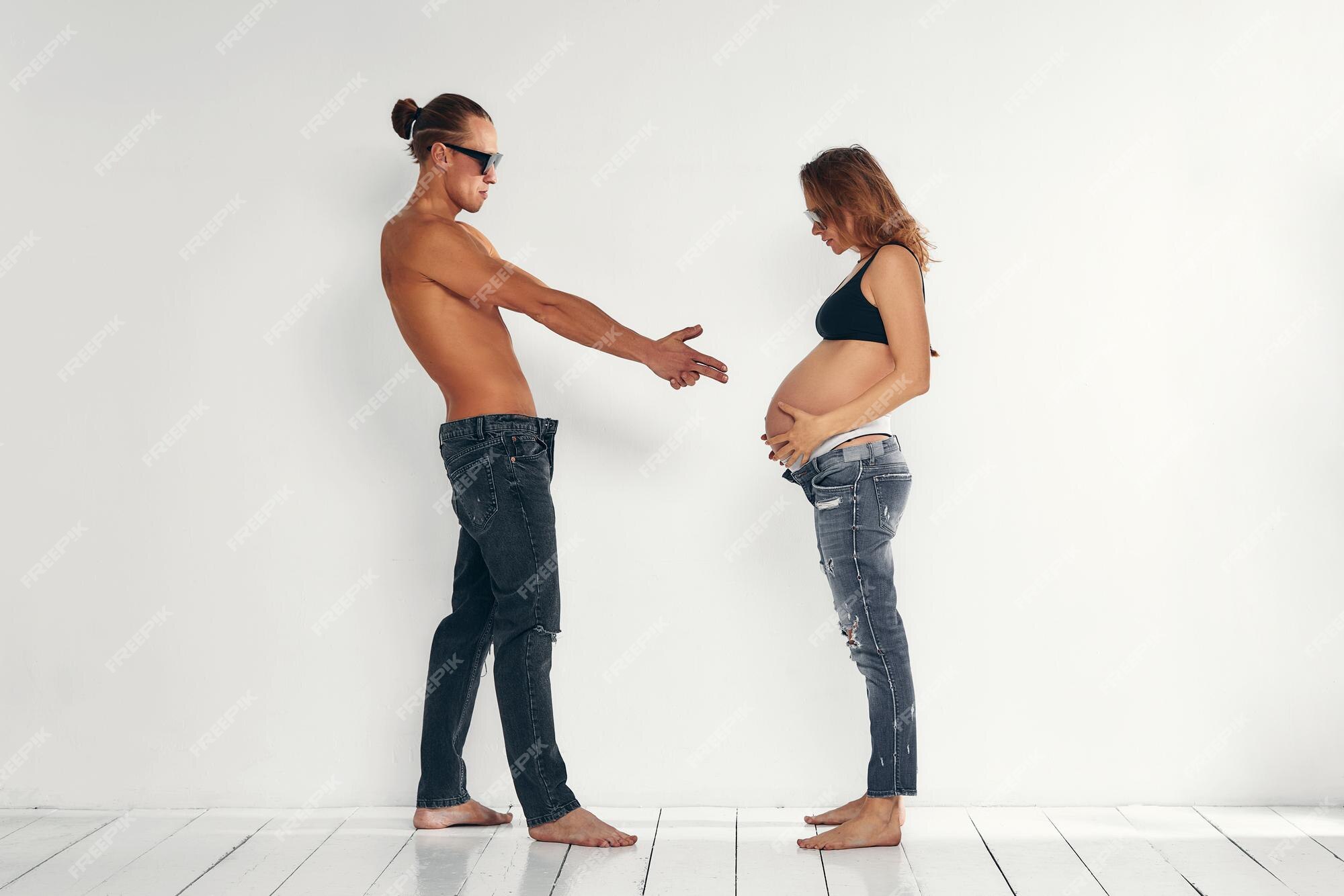 Premium Photo | Young funny couple expecting a baby man pointing hand and fingers to pregnant belly shooting on white background Premium Photo | Young funny couple expecting a baby man pointing hand and fingers to pregnant belly shooting on white background
