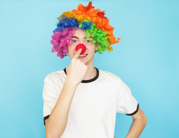 Young funny male teenager in white t-shirt on blue background