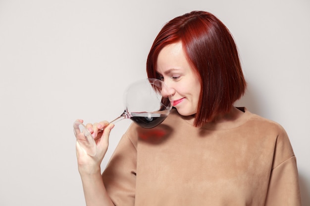 Giovane sommelier dai capelli rossi divertente della donna con il vetro di vino