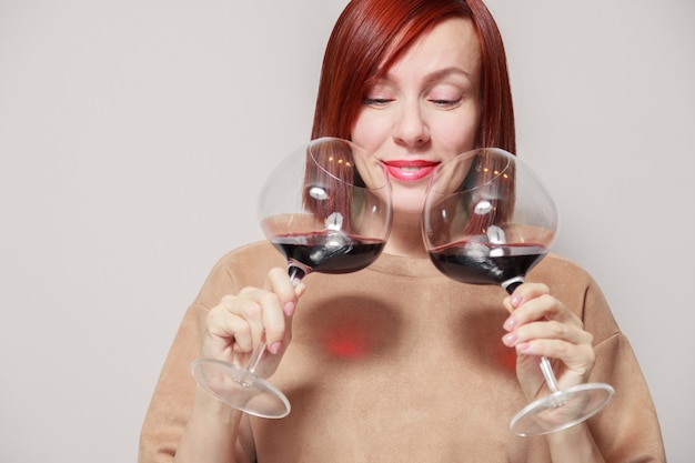 Giovane sommelier dai capelli rossi divertente della donna con i vetri di vino