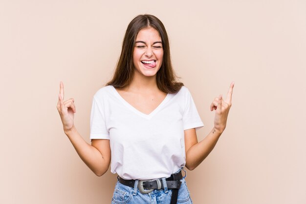 Young funny woman isolated on beige wall