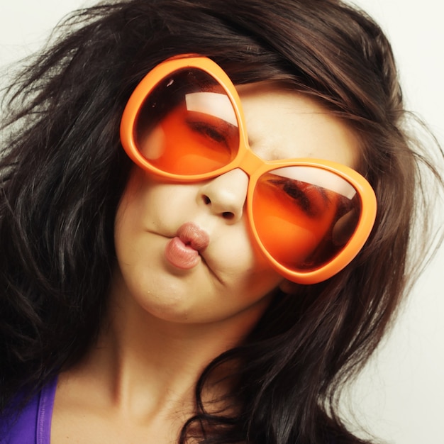 Young funny woman with big orange sunglasses