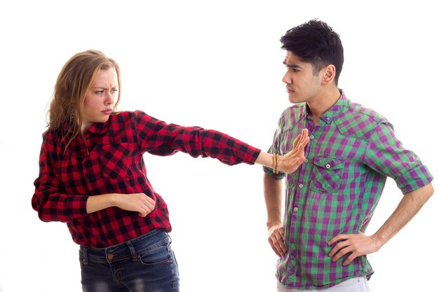 Young funny woman with young handsome man with dark hair in plaid shirts holding white placard