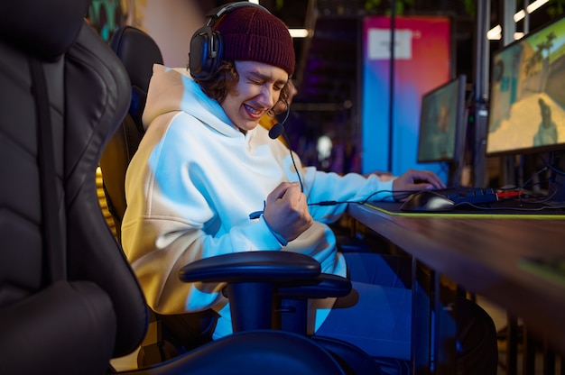 Young gamer in headphones play in game club