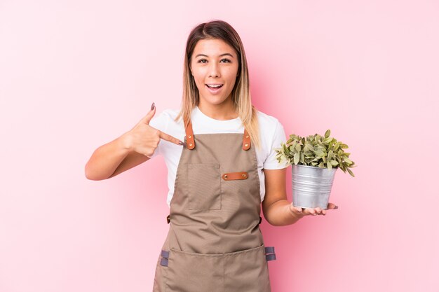 Young gardener caucasian woman isolated person pointing by hand to a shirt copy space, proud and confident