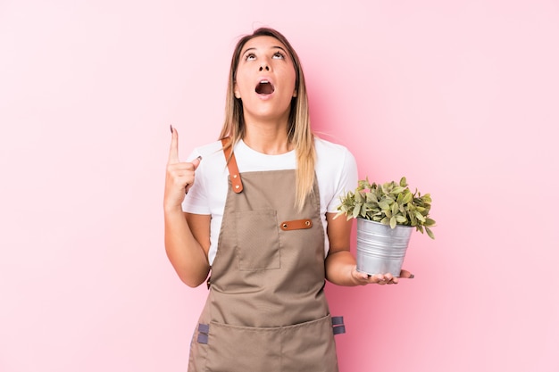 Young gardener caucasian woman isolated pointing upside with opened mouth.