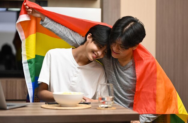 LGBTQ 프라이드 플래그 아래 젊은 게이 커플 성적인 자유와 LGBT 커뮤니티에 대한 평등권 개념