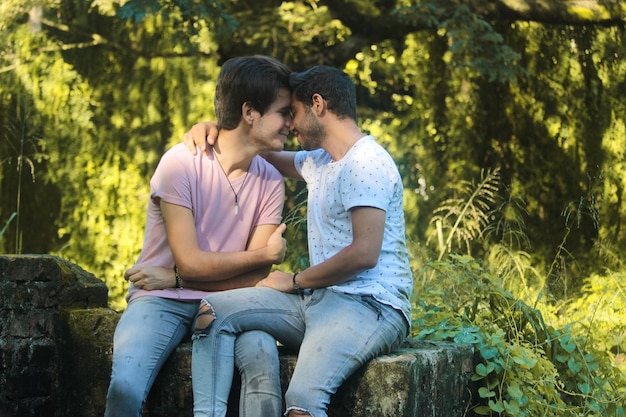 Una giovane coppia maschio gay che si bacia nel parco