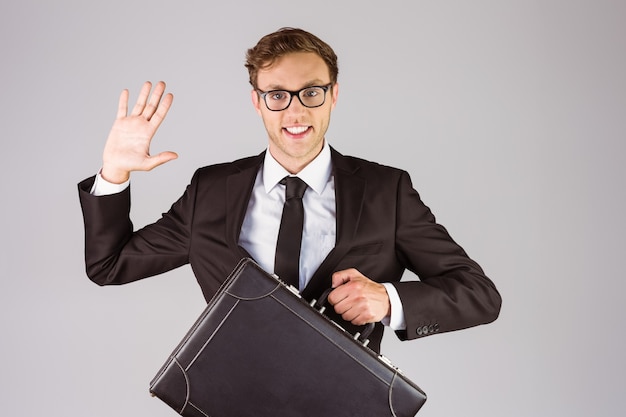 Young geeky businessman holding briefcase