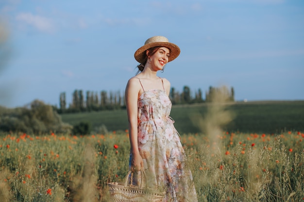 Young gentle woman relaxing in sunset light beam. Full lenght portrait in flower field