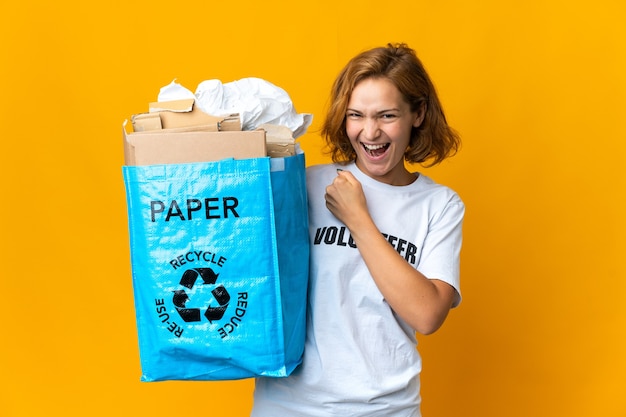 Young Georgian girl holding a recycling bag full of paper to recycle celebrating a victory