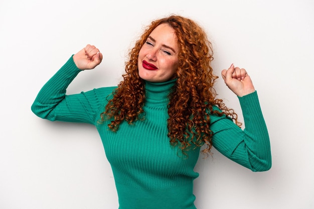 Young ginger caucasian woman isolated on white background stretching arms relaxed position