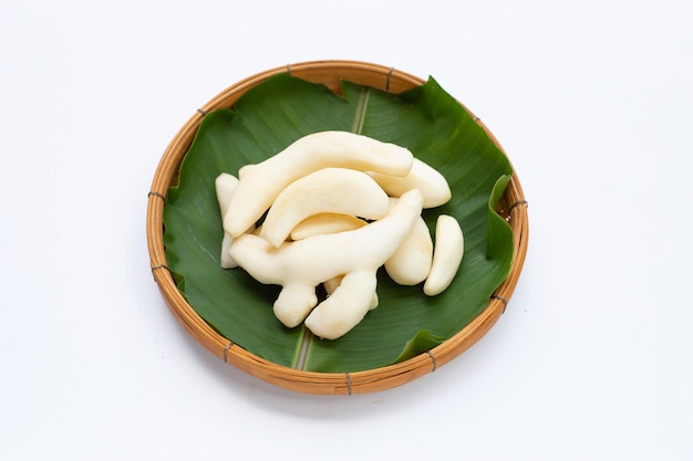 Young ginger peeled in bamboo basket on white background.