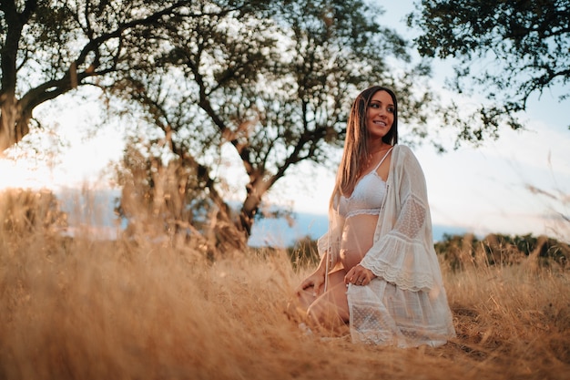 Young girl about to have a baby in nature taking pictures in her underwear