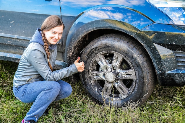 Foto una giovane ragazza ammira la sua auto fuoristrada sport e attività ricreative