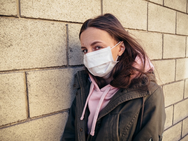 Young girl alone on an empty street in a medical mask.