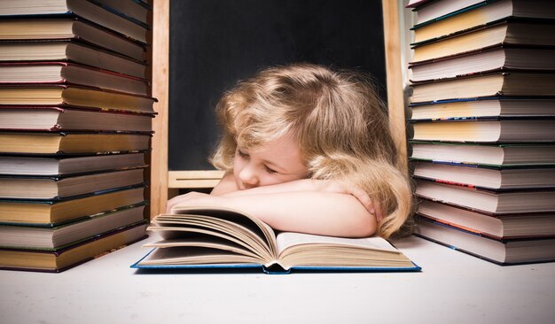 Young girl asleep on book at desk