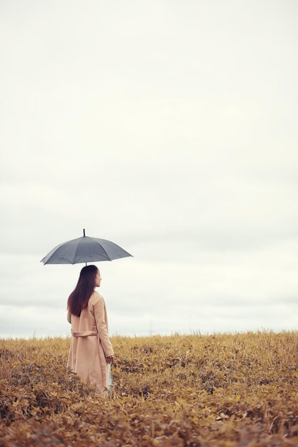 Молодая девушка осенью в дождливую погоду