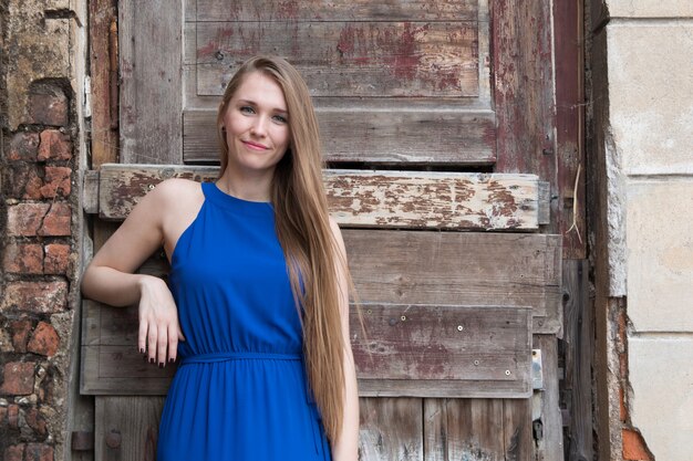 Young girl on background of old wall with door