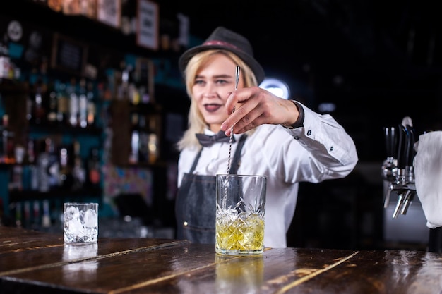 Young girl barkeeper makes a show creating a cocktail in cocktail bars