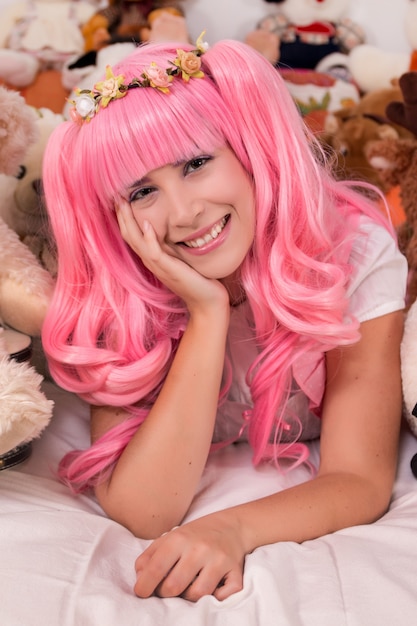 Young girl in a bedroom in a pink cute dress