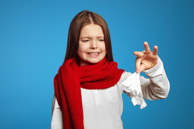 Young girl being disgusted for the tissue she is holding up isolated over