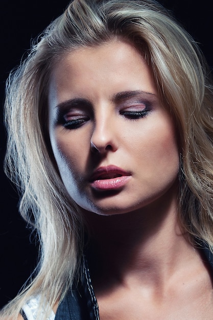 Young, girl, blonde, jeans, clothes on a dark background portrait, close-up