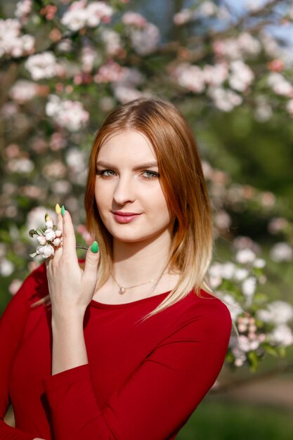 Young girl in a blooming apple orchard