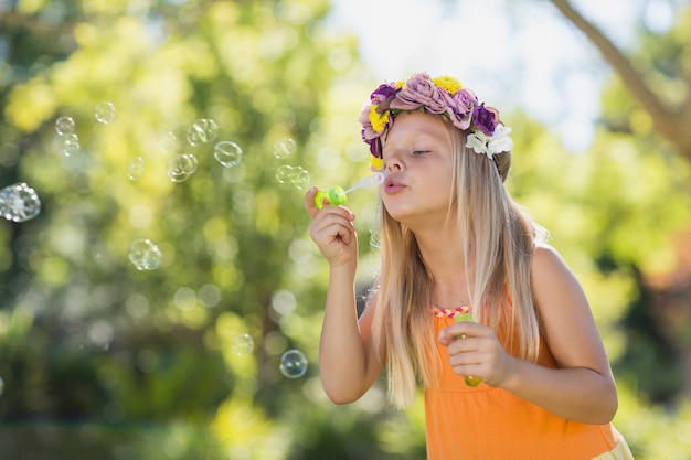 Young girl blowing bubbles through bubble wand