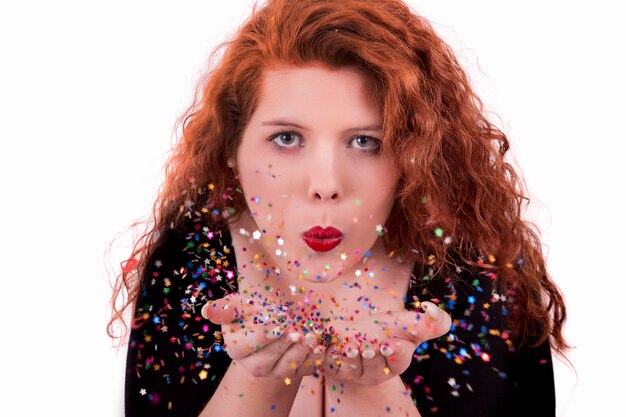 Photo young girl blowing confetti