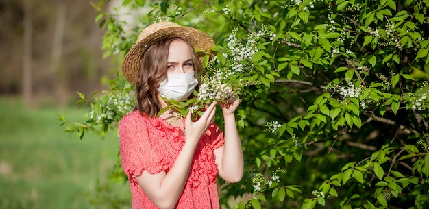 若い女の子の鼻をかむと咲く木の前にティッシュでくしゃみ。人に影響を及ぼす季節性アレルゲン。美しい女性には鼻炎があります。