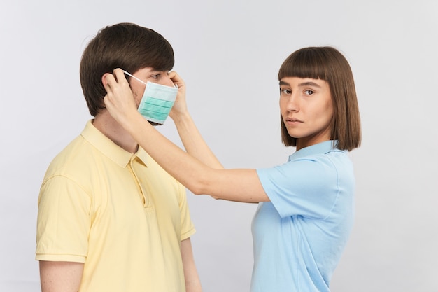 Young girl in blue shirt putting on man face protective mask