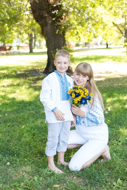어린 소녀와 소년이 노란 꽃다발을 들고 사진을 찍기 위해 포즈를 취합니다.