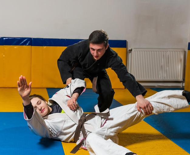 Photo young girl and boy practice brazilian jiu jitsu in the gym