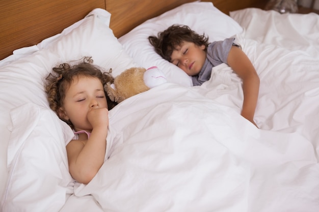 Young girl and boy sleeping in bed