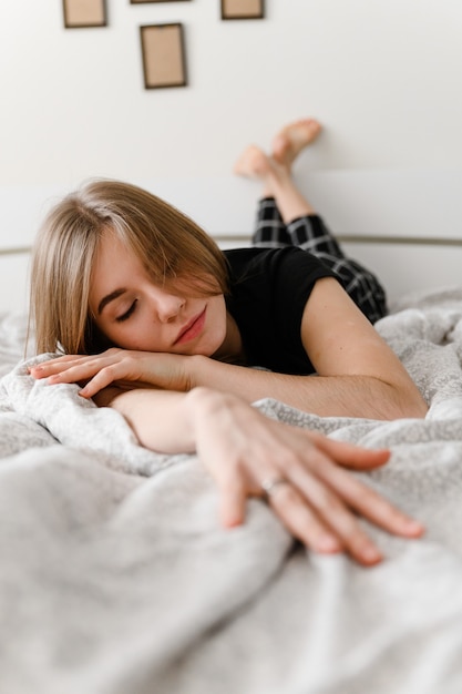 young girl cheerfully lies in bed.