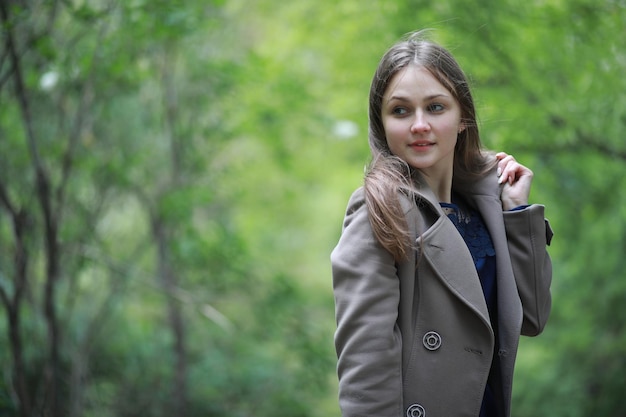 Young girl in a coat in a spring park