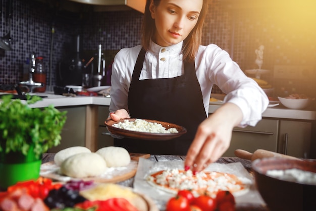 Young girl cooking pizza