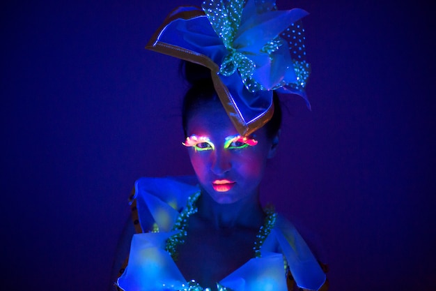 Young girl in costume with neon glow make up