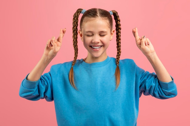 Photo young girl crossing fingers for good luck