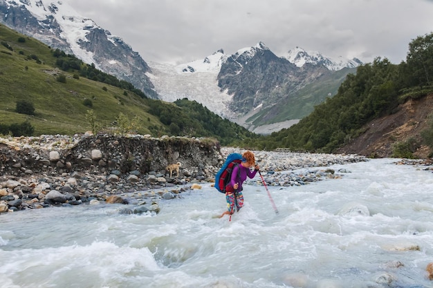 Young girl crossing mountain river barefoot Caucasus Svaneti