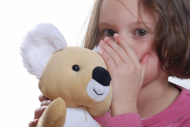 Young girl cuddling teddy bear