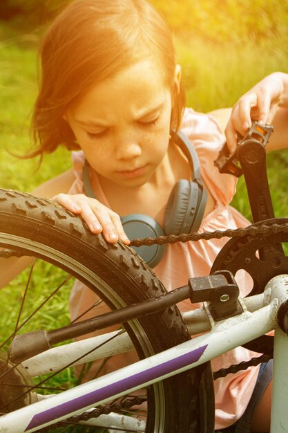 어린 소녀 자전거 타는 여름 숲 트레일에서 아름다운 해가 뜨는 것을 즐긴다