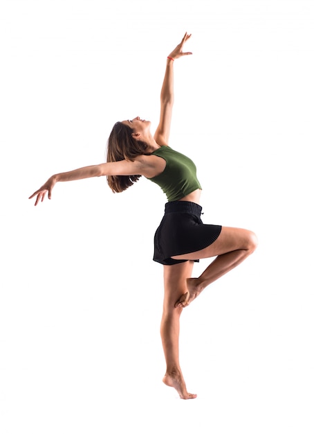 Young girl dancing and jumping in studio on isolated background