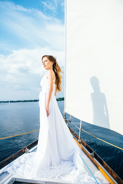 Young girl on deck of sailing wooden white yacht