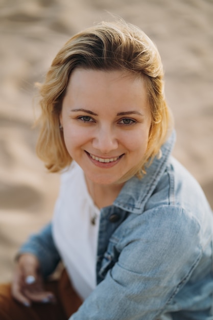 young girl in denim jacket  enjoy sun on beach on summer evening