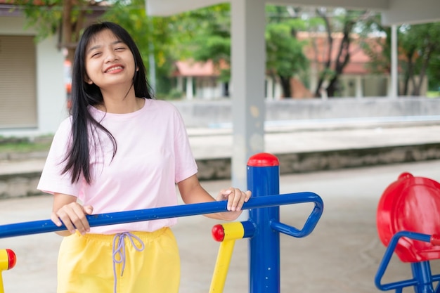 カラフルな機器の運動で運動をしている若い女の子