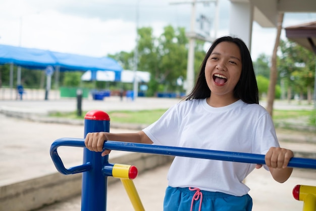 カラフルな機器の運動で運動をしている若い女の子