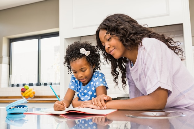 Photo young girl doing her homework with her mother